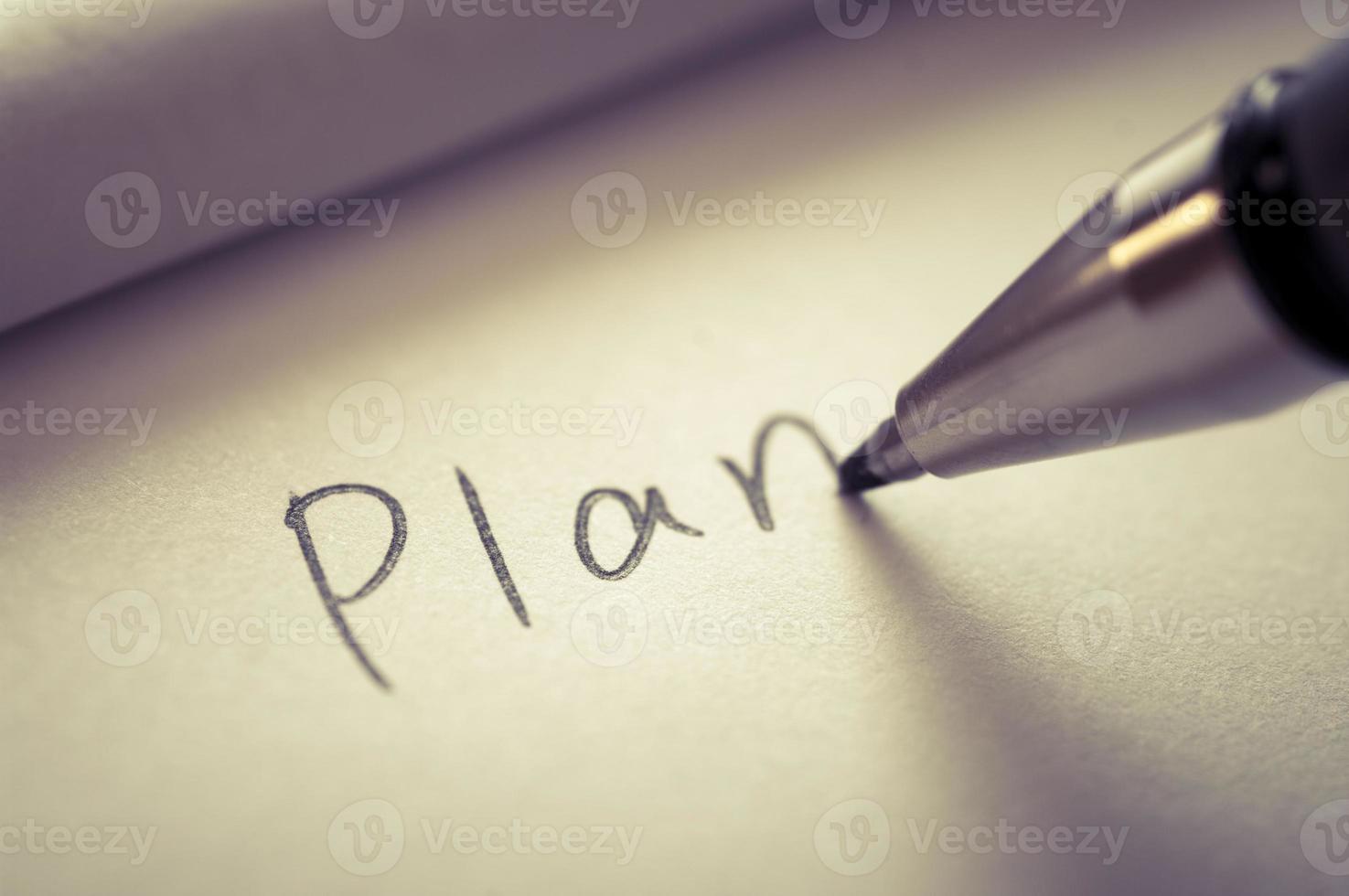 Close up image of writing a word PLAN on a notebook paper. photo