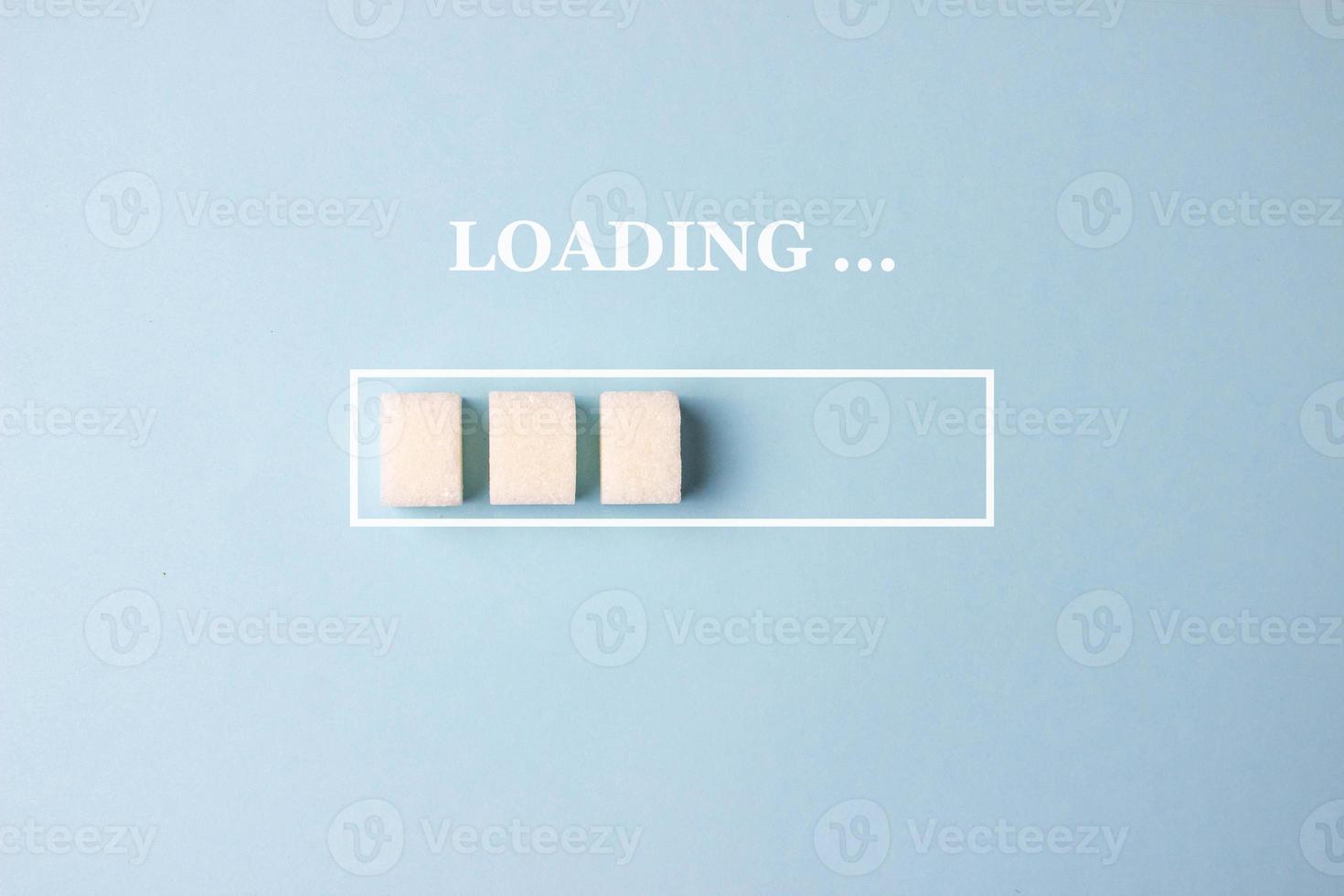 Loading background with sugar cubes in progress bar on blue background. With word LOADING . Concept download photo