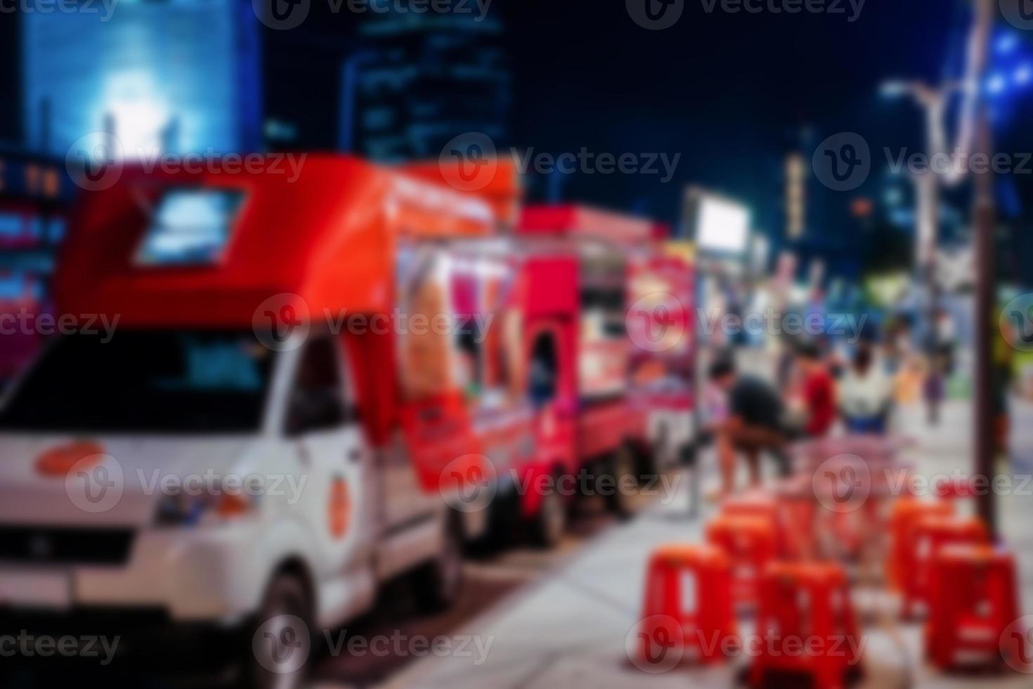 blur photo of Thai and travel People joined foodtrucks event that parking on the road beside footpath wait for customer to to buy food and drink. Bangkok Thailand.