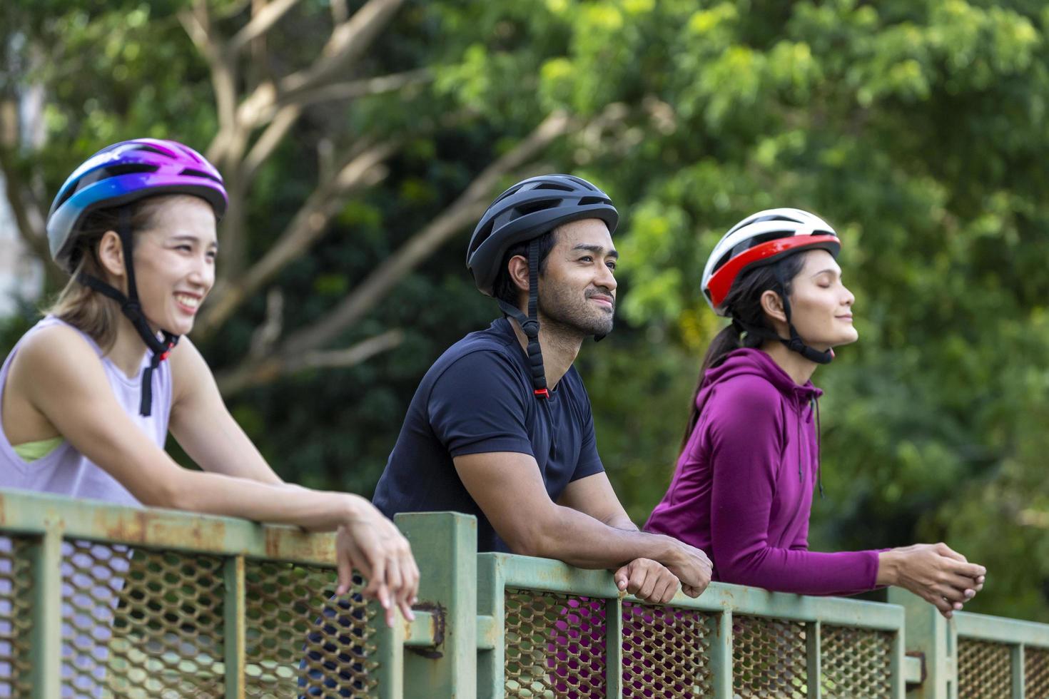 Team of Asian cycling friends taking a rest and enjoy looking at the view in public park photo