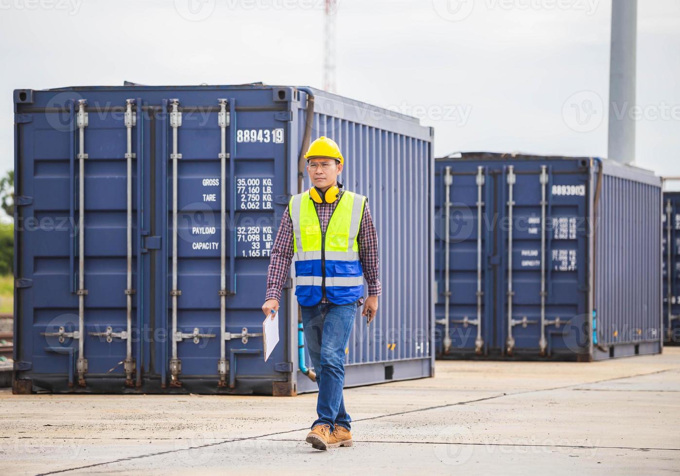 Foreman dock worker in hardhat and safety vest control loading containers box from cargo, Engineer with clipboard checklist in industry containers cargo photo