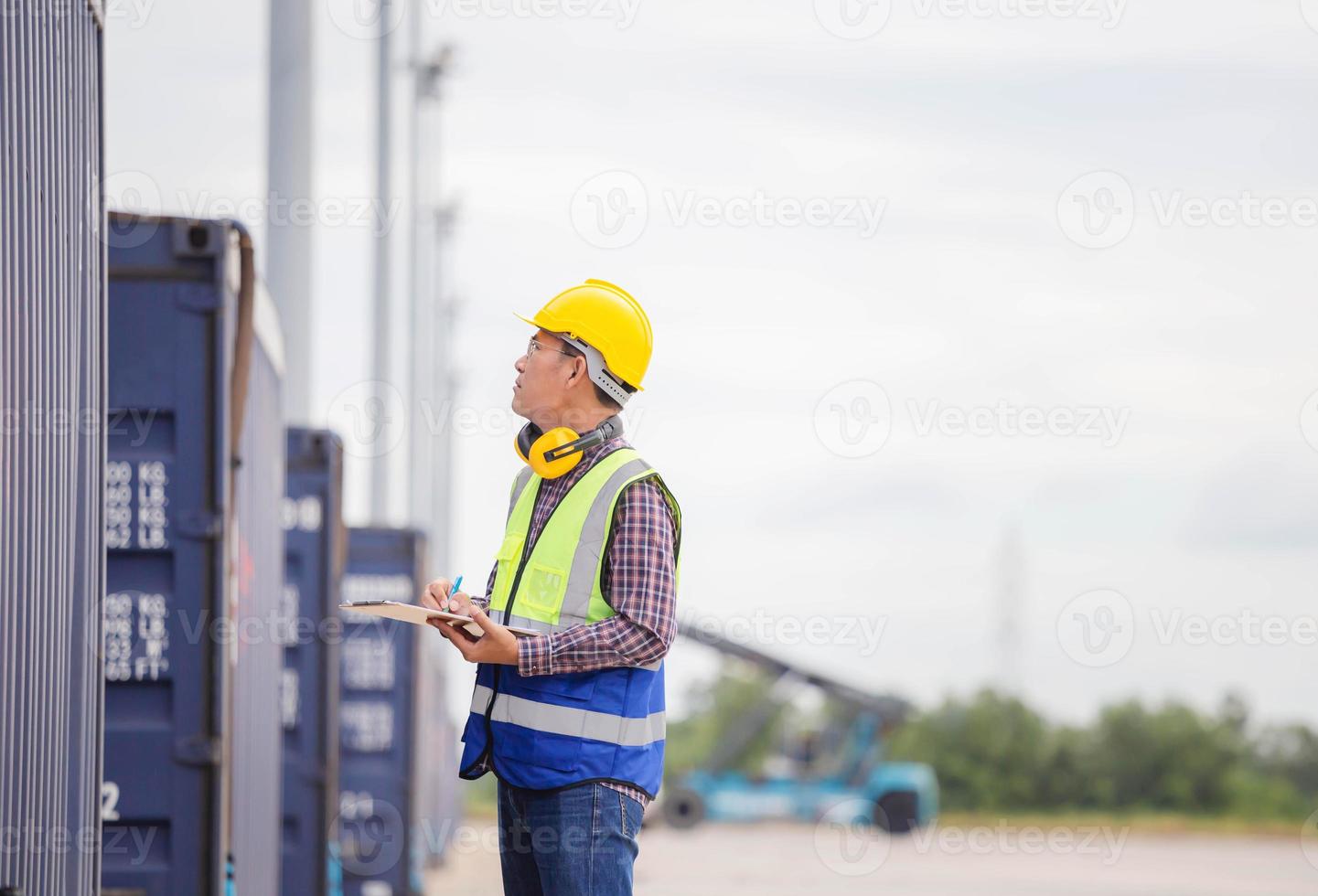 trabajador portuario capataz en casco y control de chaleco de seguridad caja de contenedores de carga de carga, ingeniero con lista de verificación de portapapeles en contenedores de carga de la industria foto