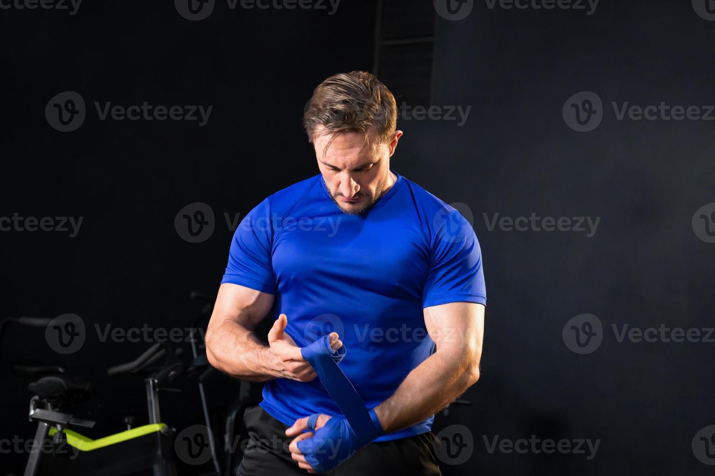 Strong boxer man wrap hands protection knuckle, Man is wrapping hands with boxing wraps for training and active exercise photo