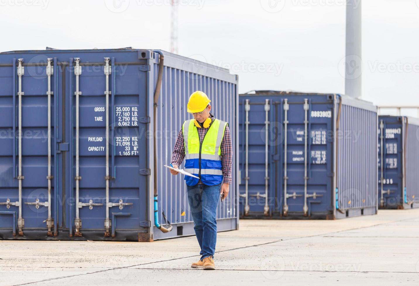 Engineer with clipboard checklist in industry containers cargo, Foreman dock worker in hardhat and safety vest control loading containers box from cargo photo