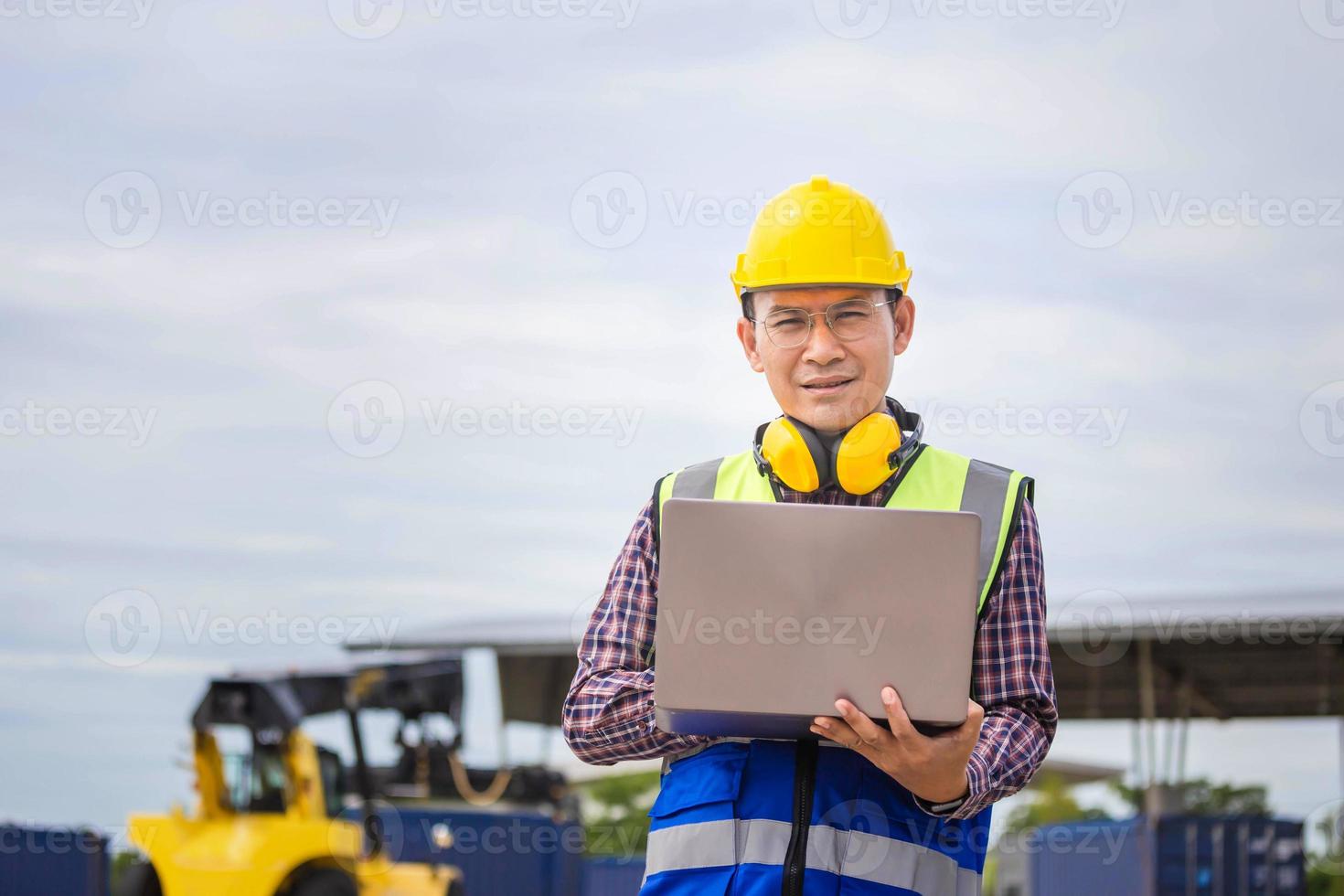 Engineer man with laptop checking and inspect the container, Foreman in hardhat and safety vest checking containers box from cargo photo
