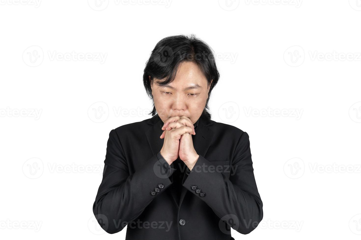 Isolated Asian business man in black suit hand together and prays for something on white background. Clipping Path. photo