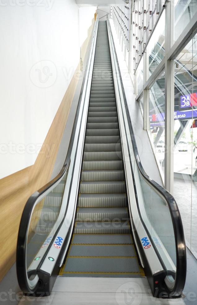 very long escalator beside the glass to outdoor side. photo