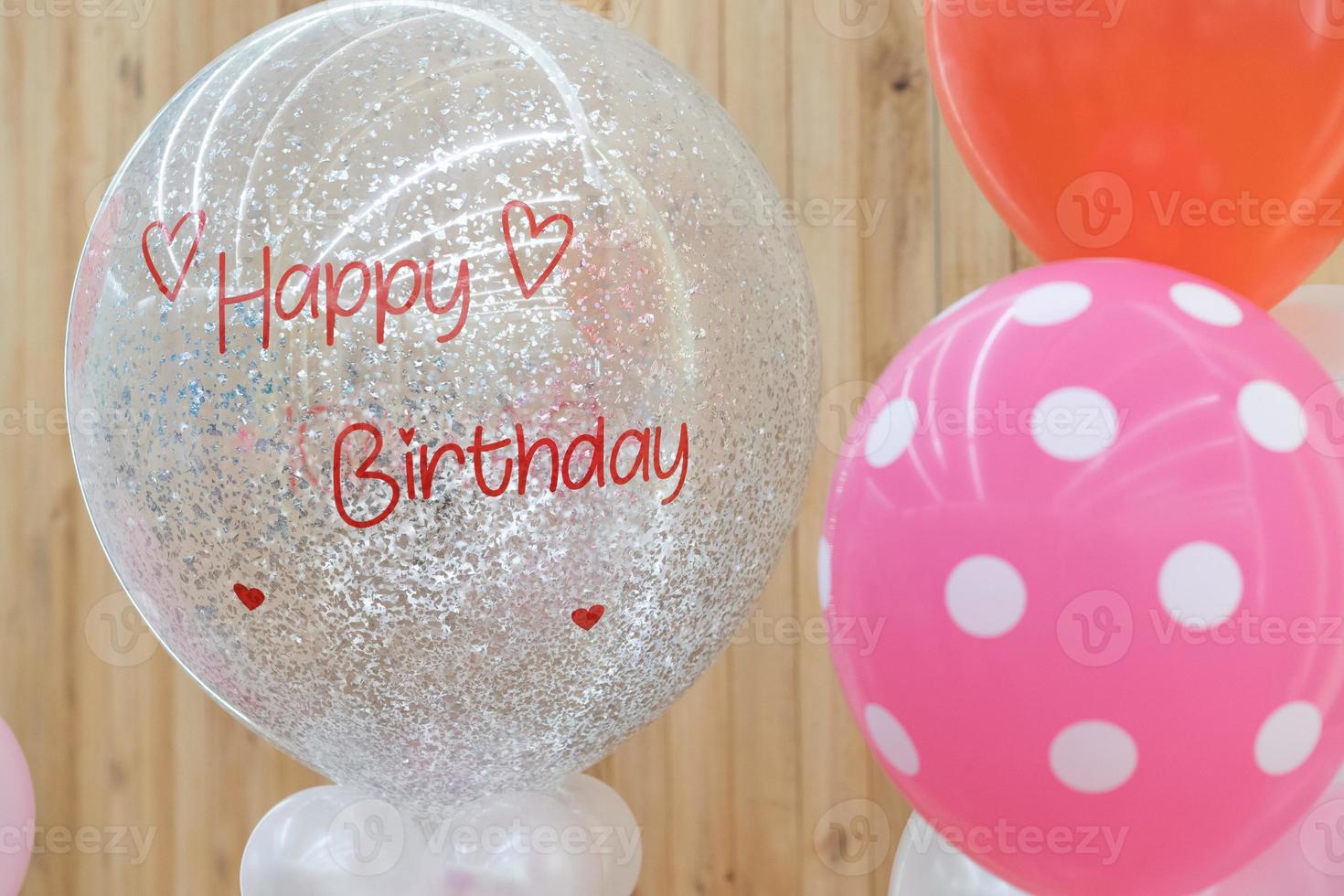 un texto de feliz cumpleaños en el globo para regalo en la fiesta de cumpleaños frente al fondo de madera. foto