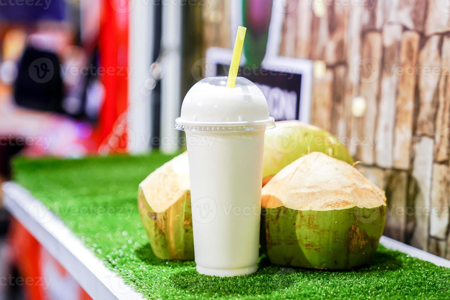 coconut mixed with milk ready for drink, stand by at the front of the real coconut. photo