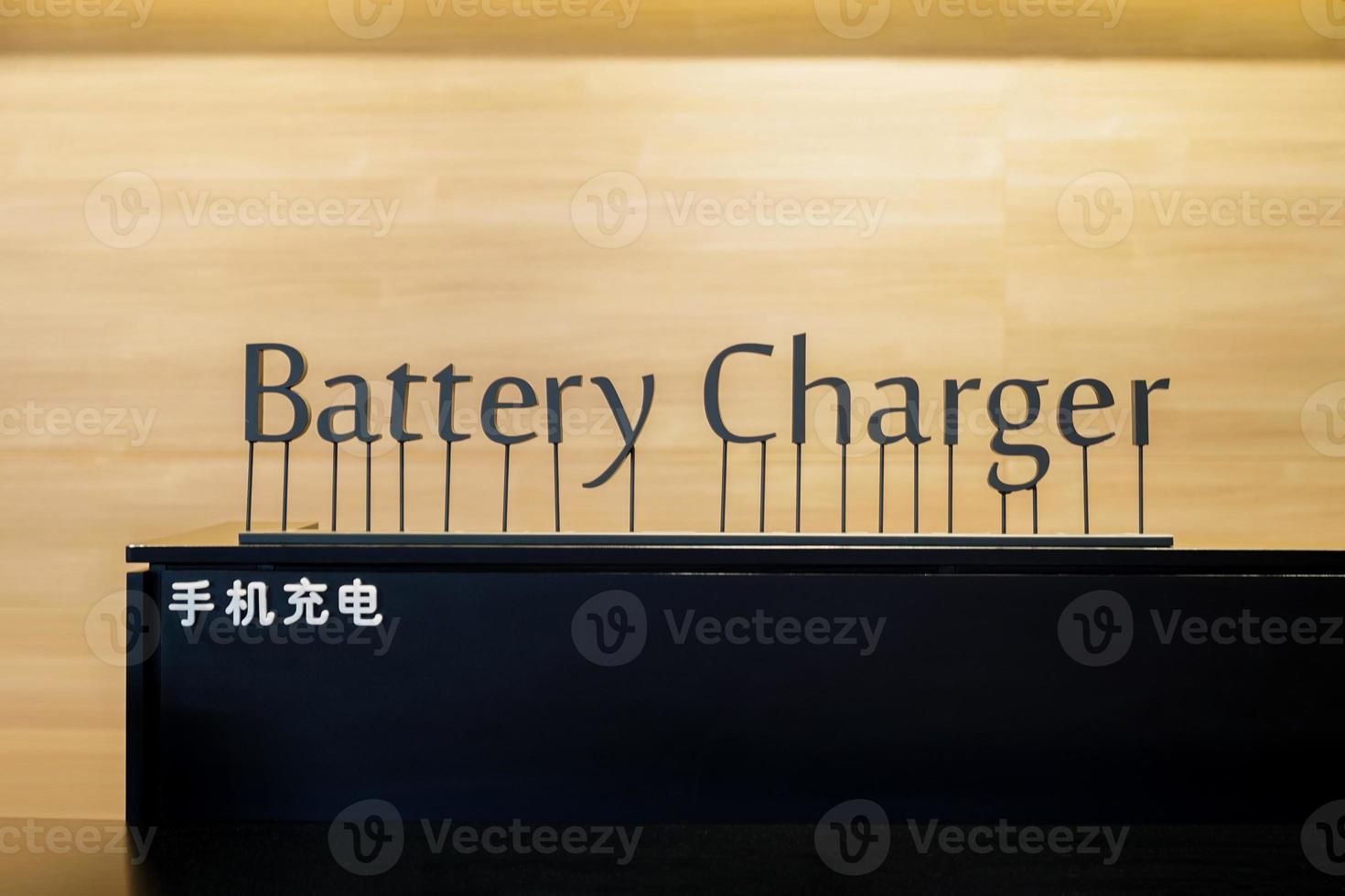 Battery Charger Art Letter pop-up sign on the black counter with Chinese Language. Chinese Laguage in picture mean battery charger. photo