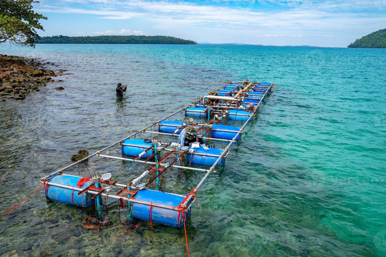 Workers settle and setup the waterworks fountain machine on the surface of the sea. photo