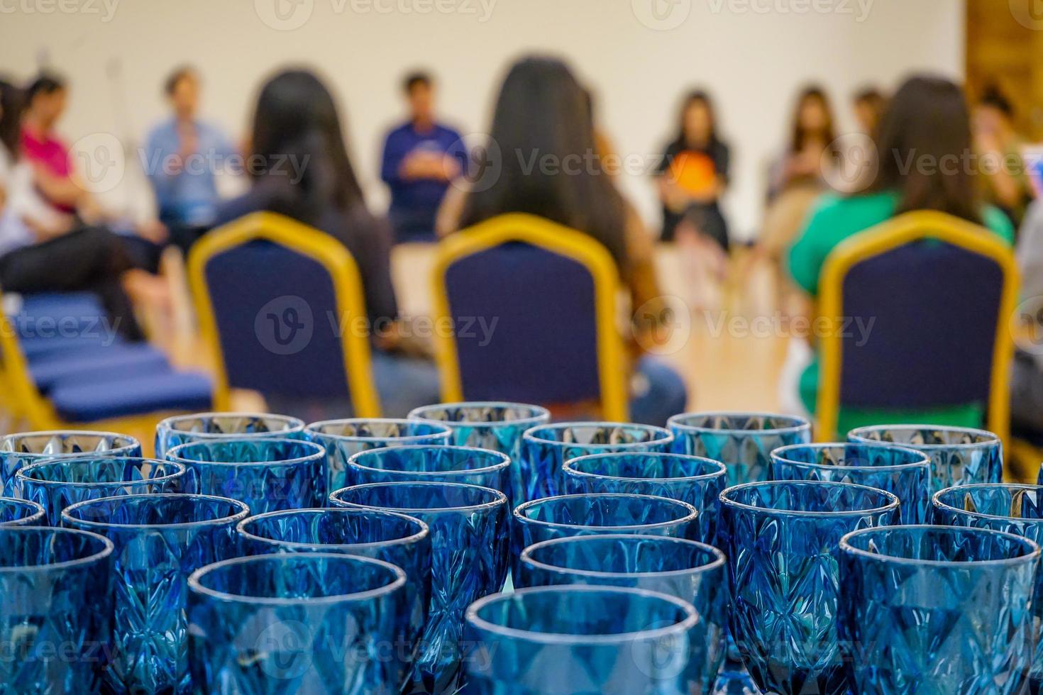 cerca de las gafas azules de lujo dispuestas detrás del evento del taller del seminario. se preparan vasos para el público y los oradores en el taller del grupo circular. foto