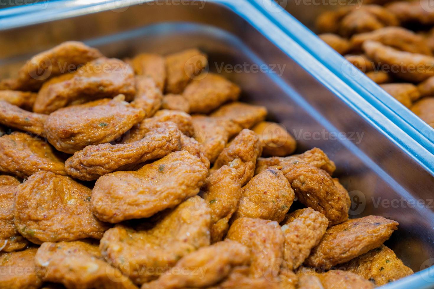 Thai fried fish paste meat balls in aluminum triangle plate on line buffet in front of seminar room. photo