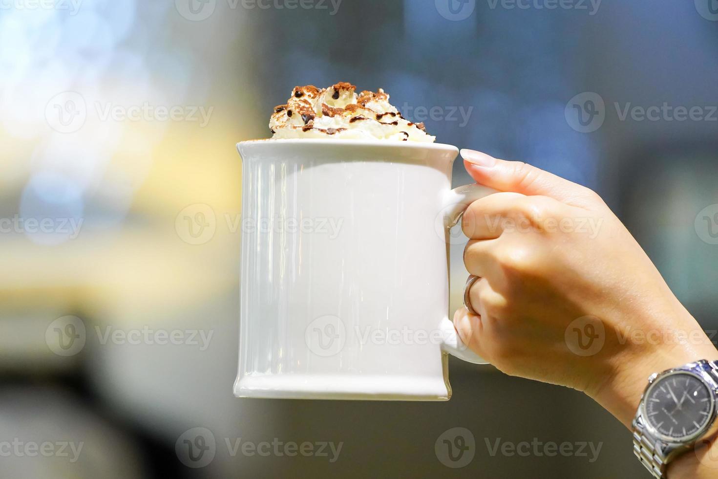 taza de café con leche y crema batida en la parte superior. foto