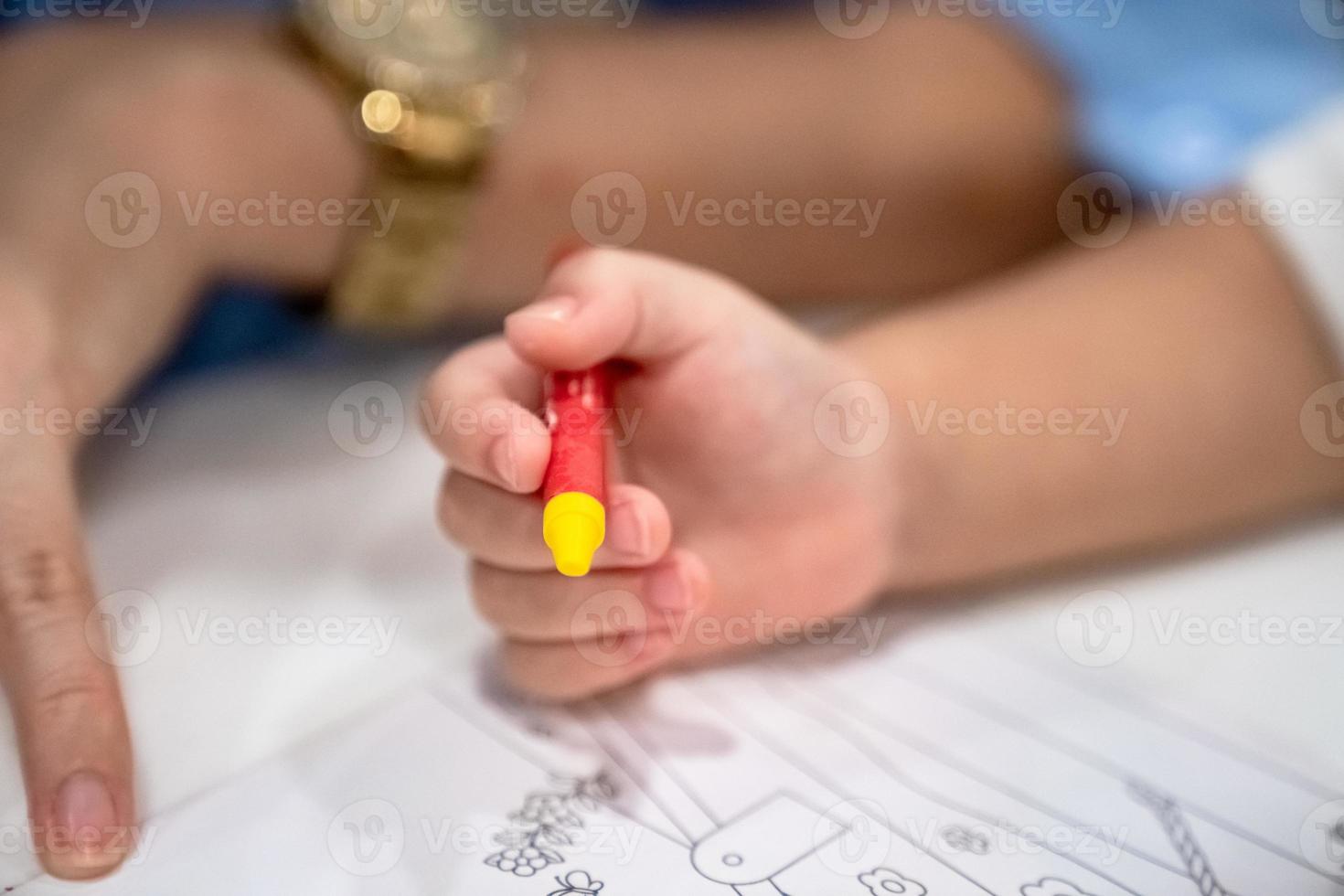 little girl plays and learns to coloring Crayon on the paper in the ice-cream restaurant., Bangkok, Thailand. photo