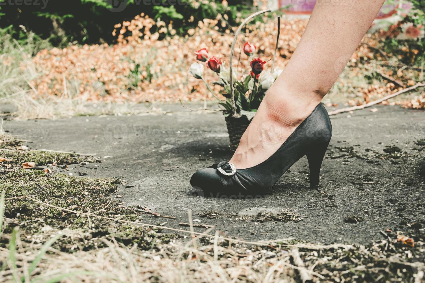 Foot of a woman wearing black high heel shoes photo