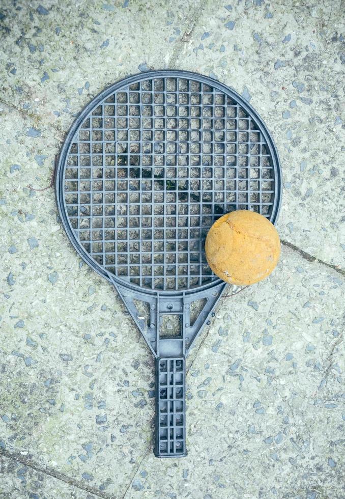 Round silver plastic toy bat and tennis ball photo