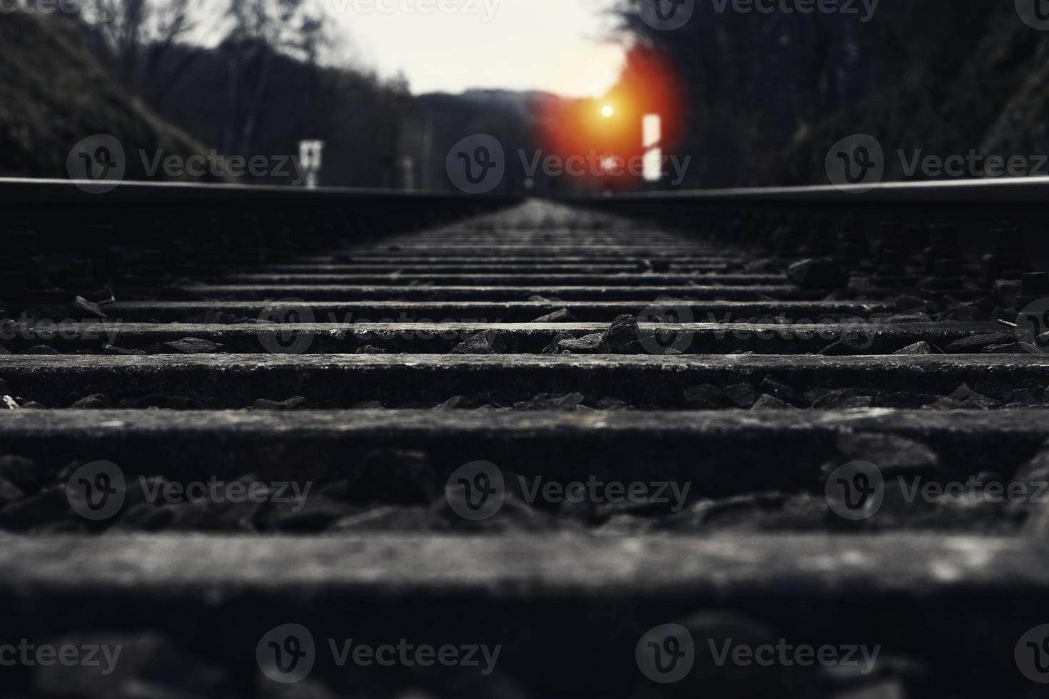 Railroad track with signal lamp in the distance photo