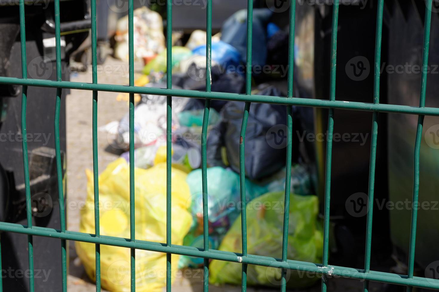 Green iron railing with bags of rubbish photo