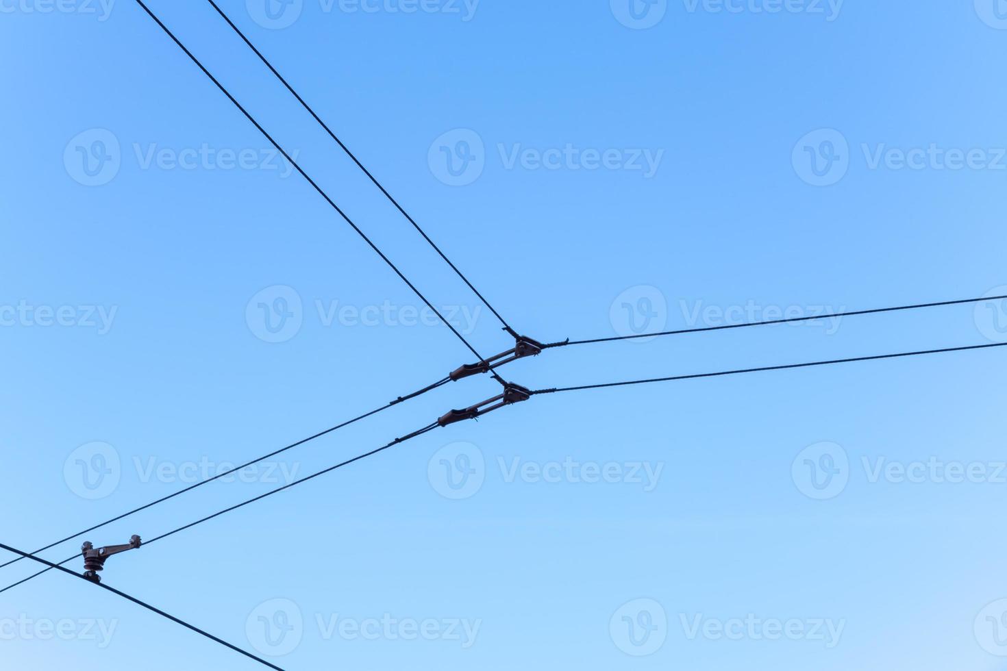 Overhead electric tram lines against a blue sky photo