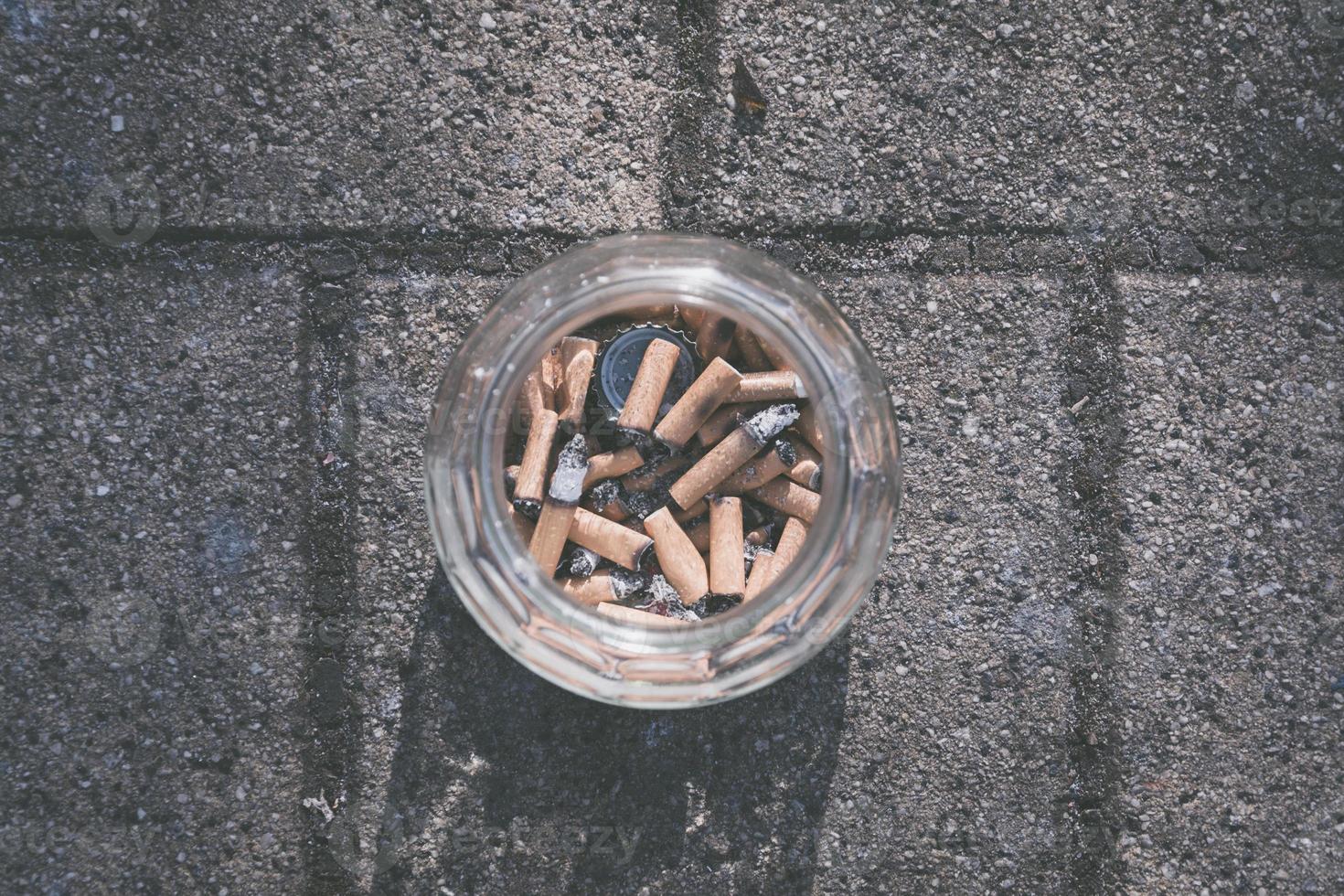 Glass ashtray full of cigarette stubs photo