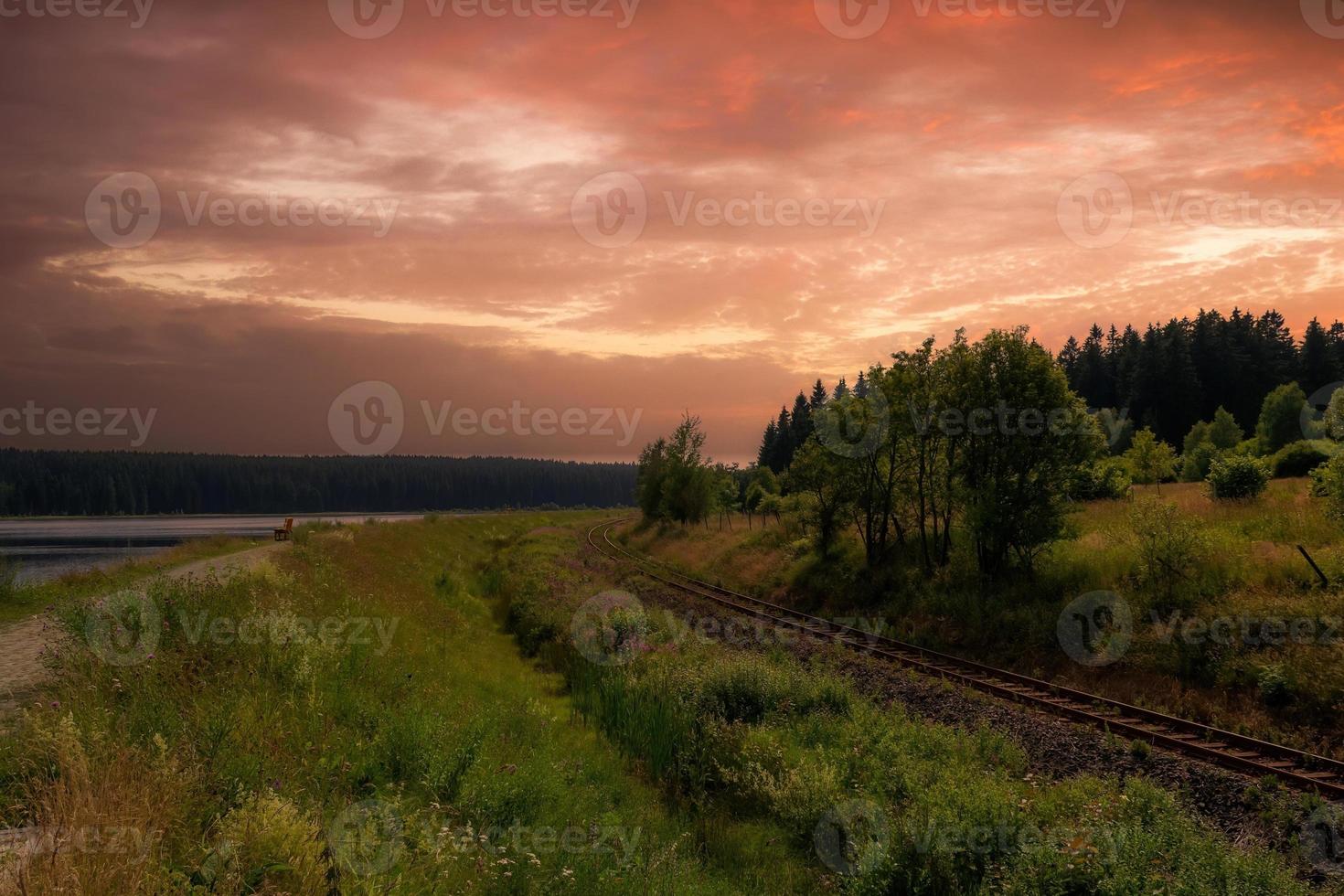 un paisaje con vía férrea al atardecer foto