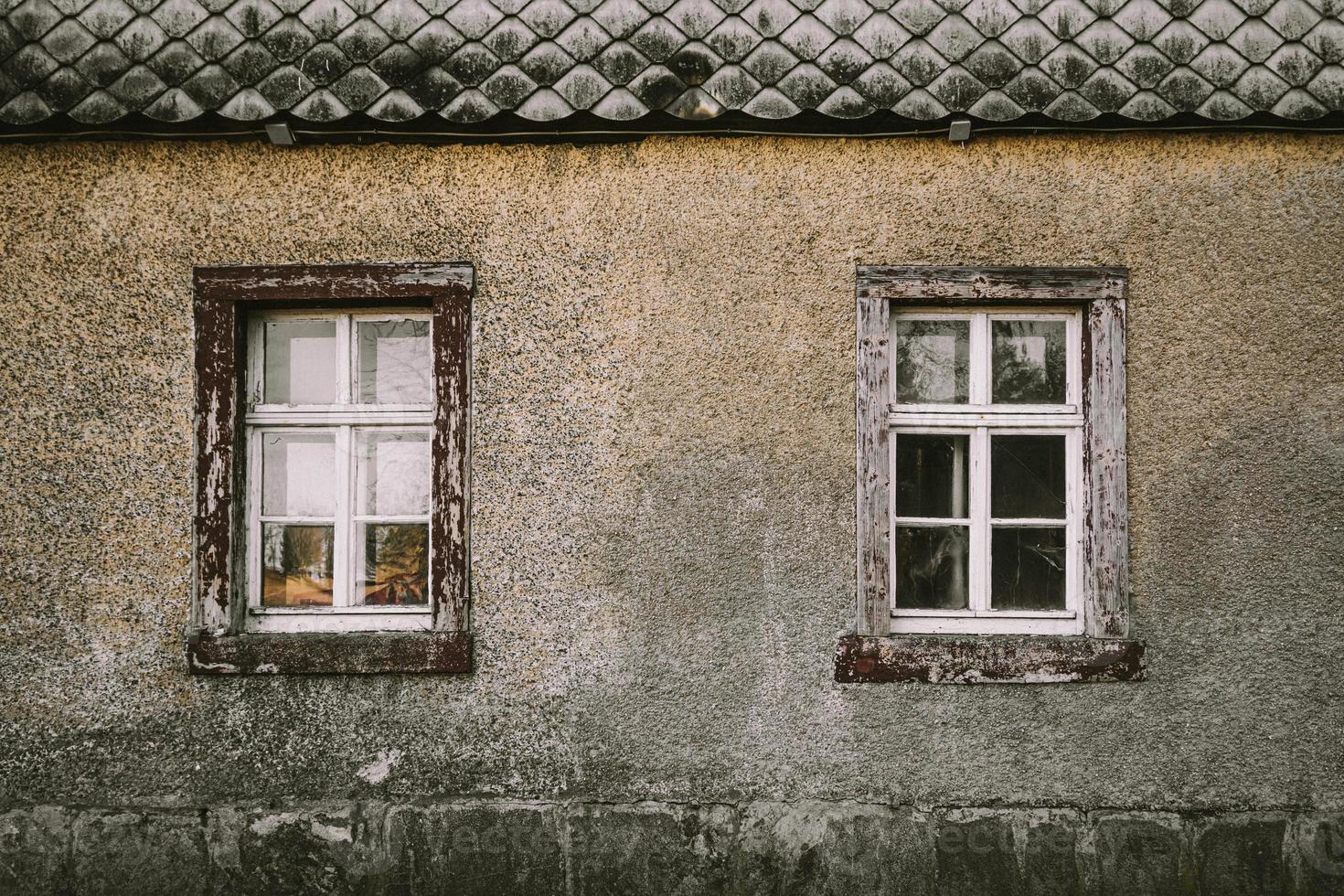 Old house grey facade with wooden windows photo