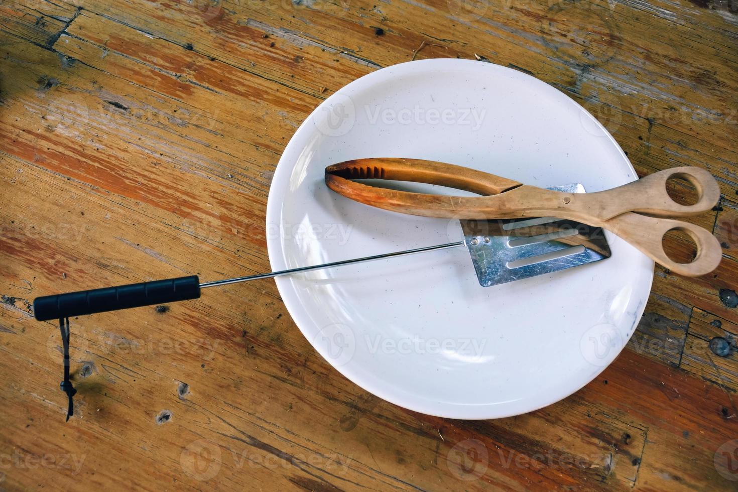 pinzas de barbacoa de madera sobre una mesa de madera rústica foto