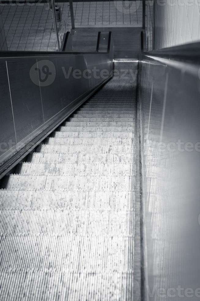 Looking down an empty escalator to the floor below photo