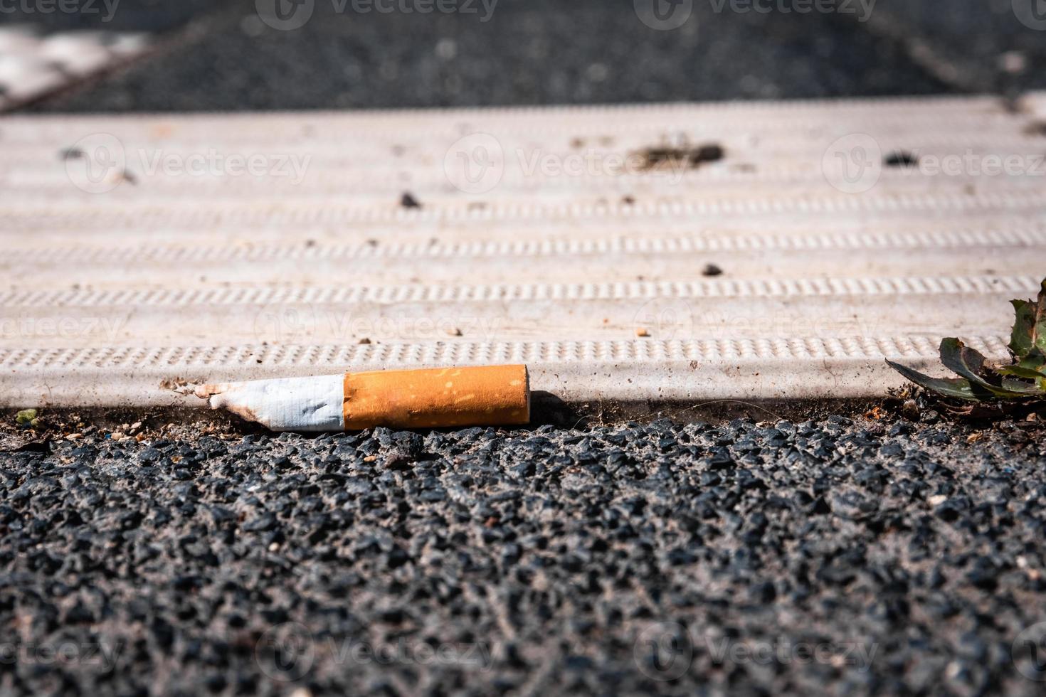 single cigarette stub on the street photo