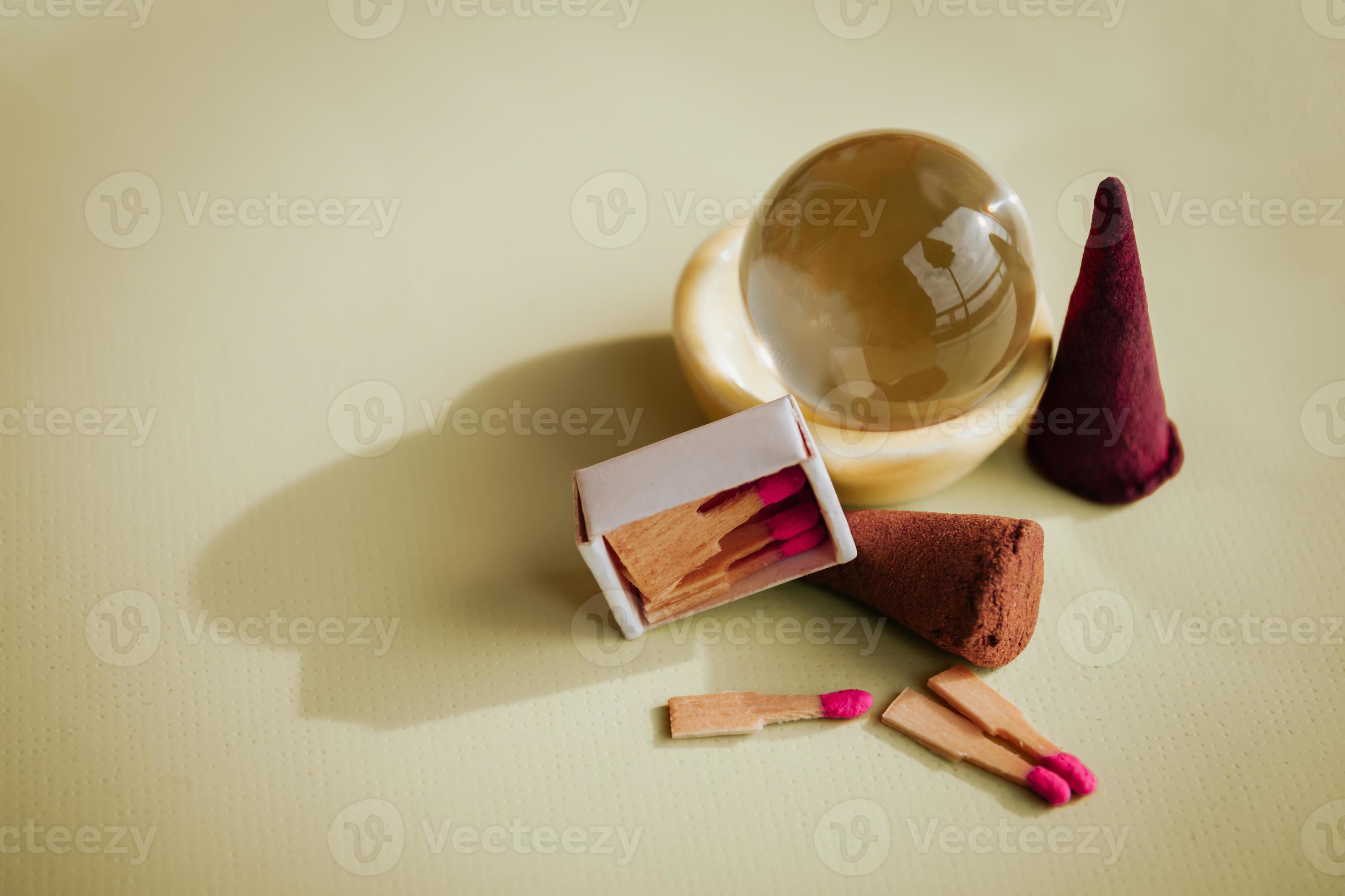 incense cones and matches on a table with a glass ball 9001072 Stock