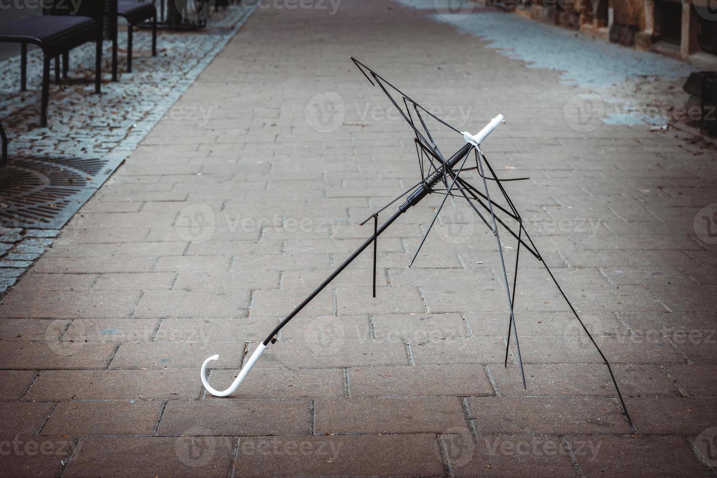 Metal white and black umbrella frame on the ground photo