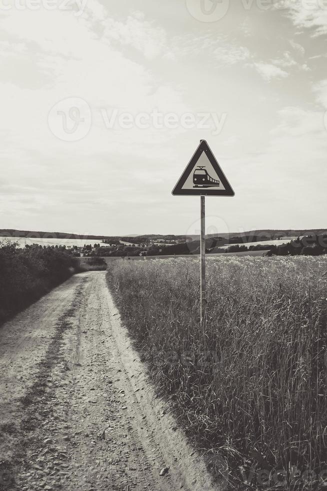 camino de tierra con señal de tráfico de tren foto