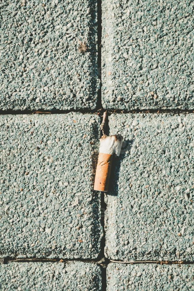 cigarette butt on a pavement photo