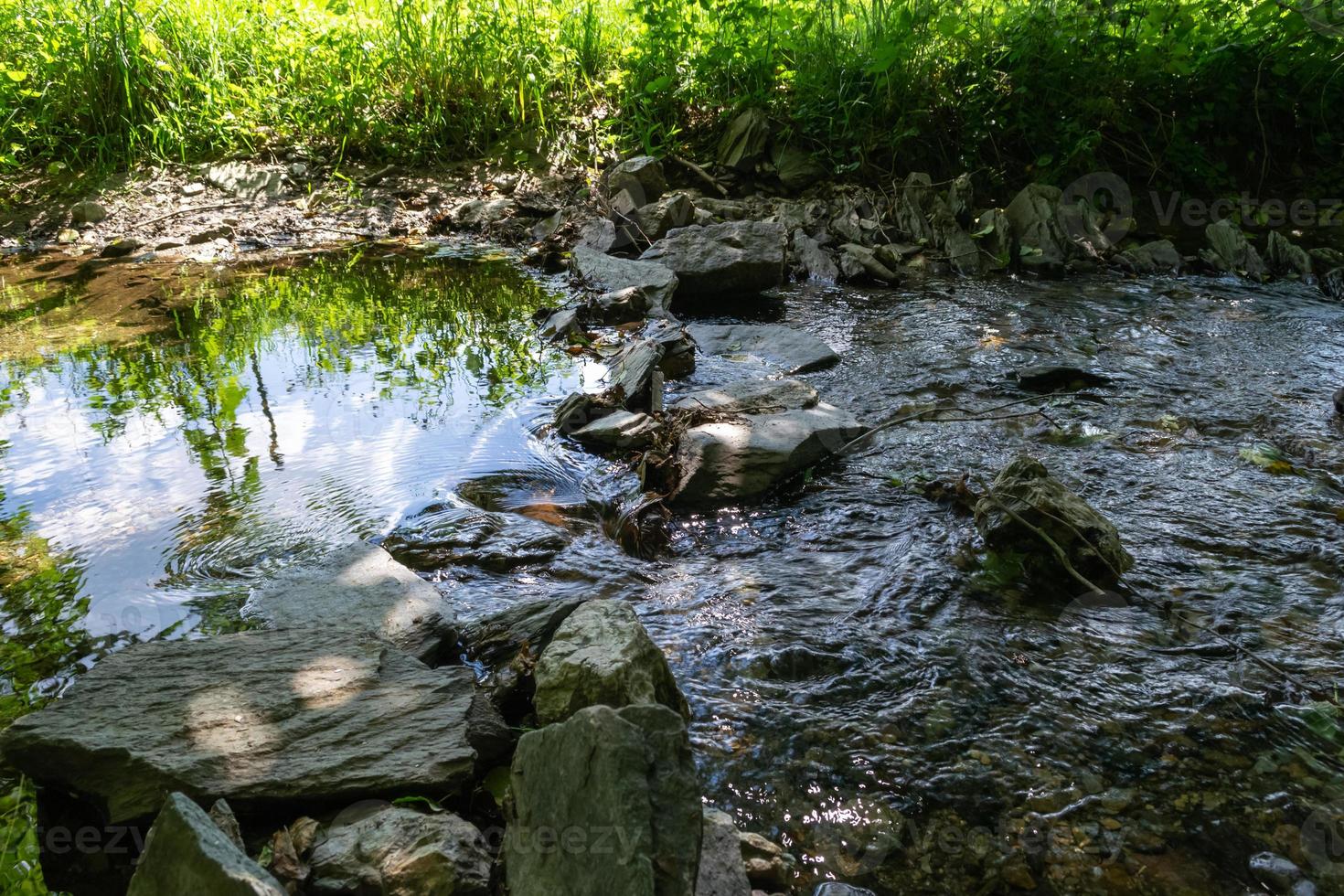 río que fluye rocas redondas en primer plano foto