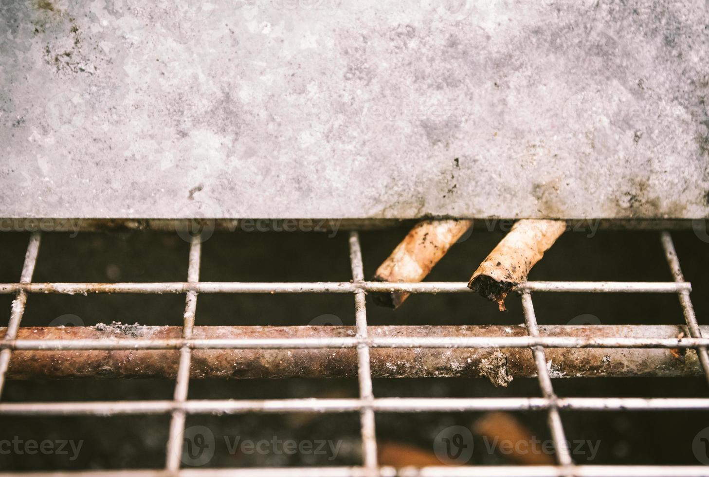 colillas de cigarrillos viejas y sucias en la papelera de la calle foto