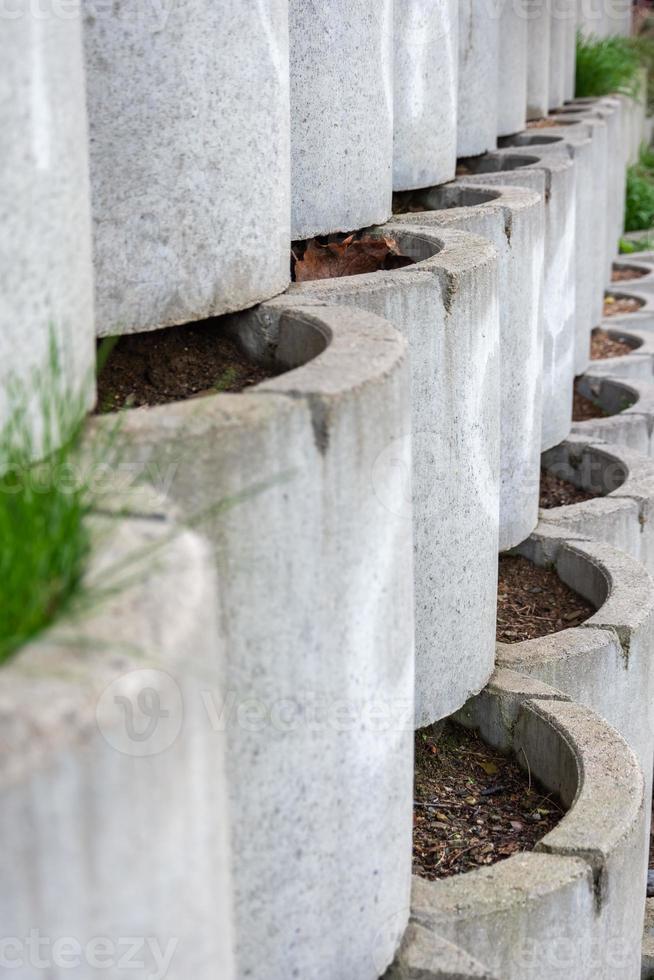 Garden wall formed of cylindrical containers photo