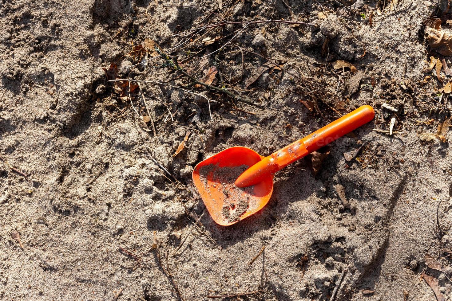 single red child shovel in the sand photo