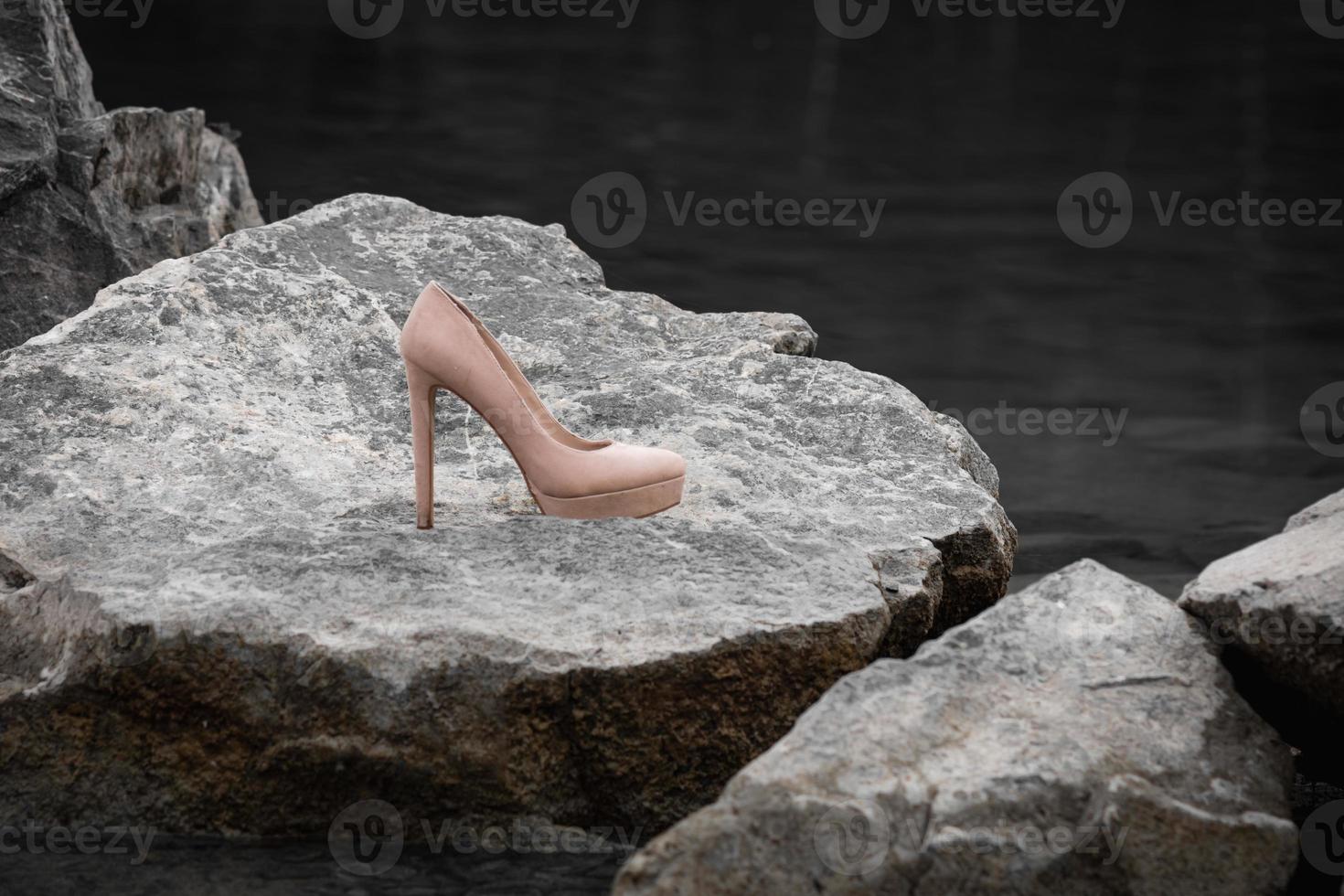 a single high heel on a rock photo