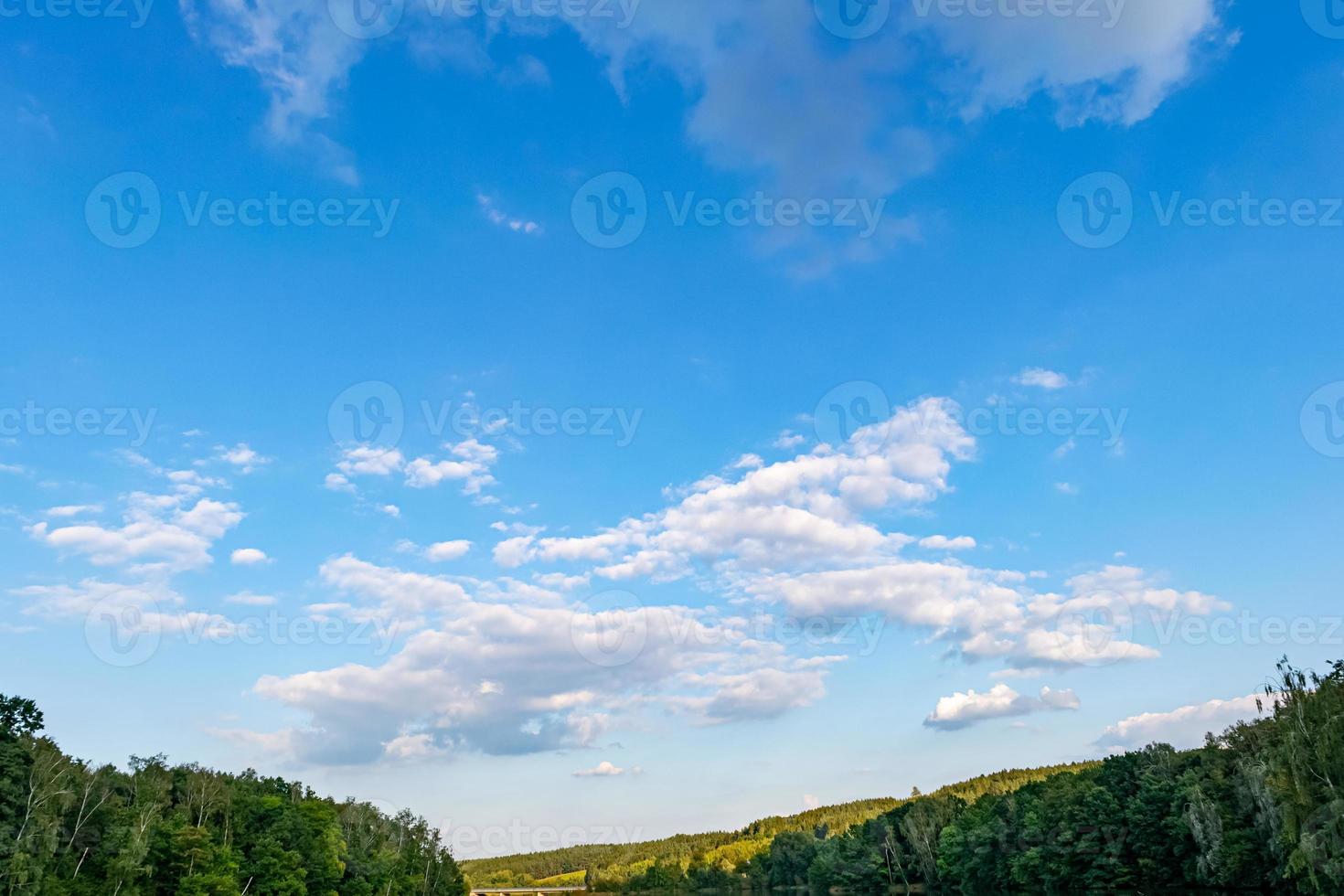 blue cloudy sky over a forest photo