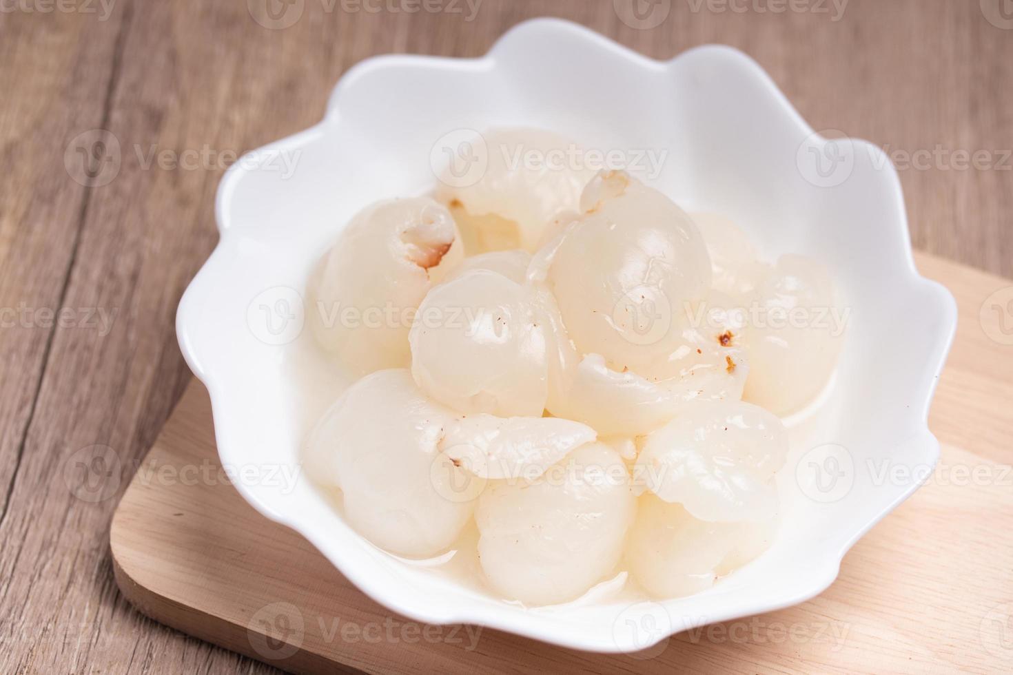 Lychee in sweet syrup in white cup. Summer snack. photo