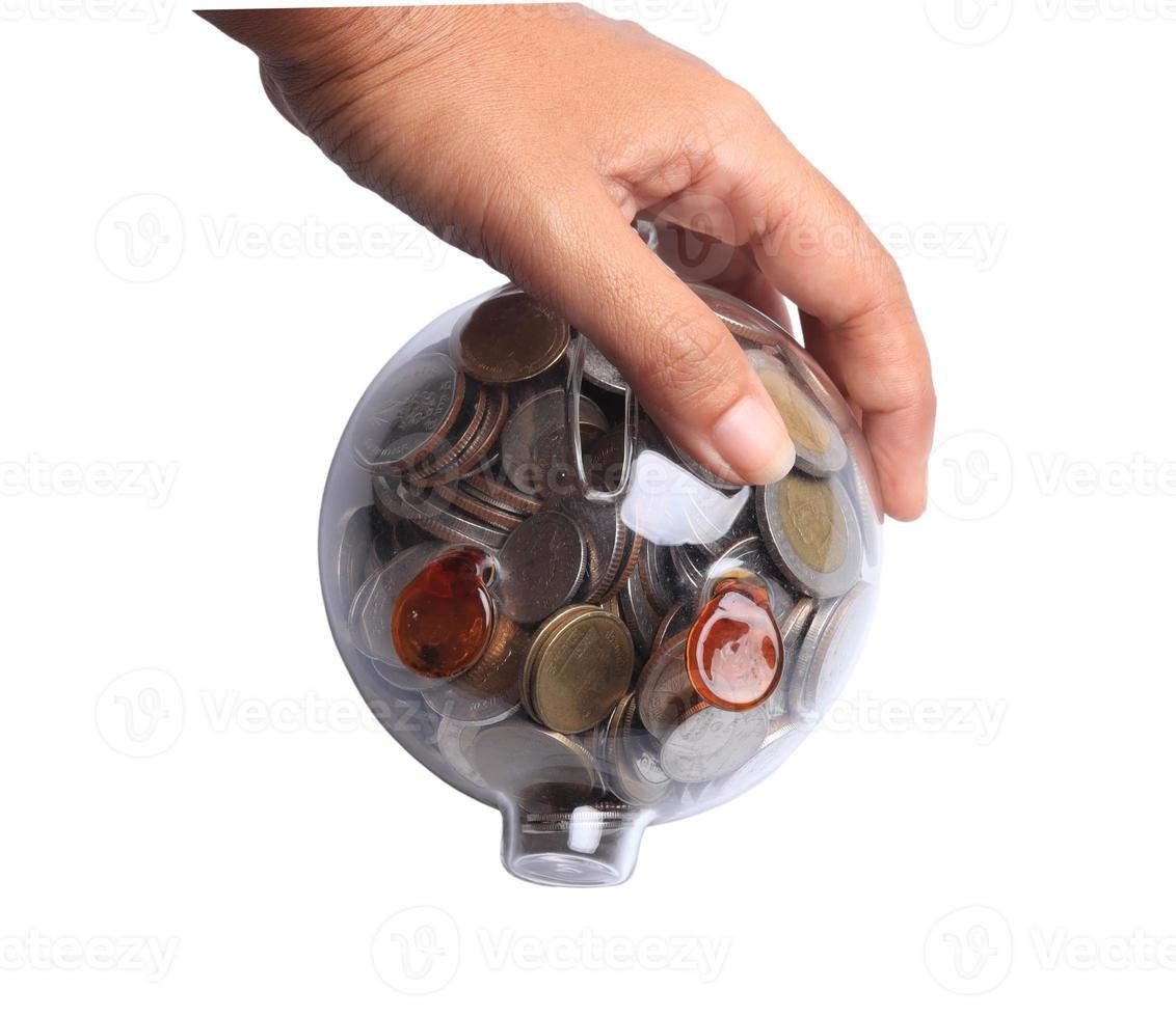 Female hand putting coin in piggy bank on white background. Money saving concept. photo