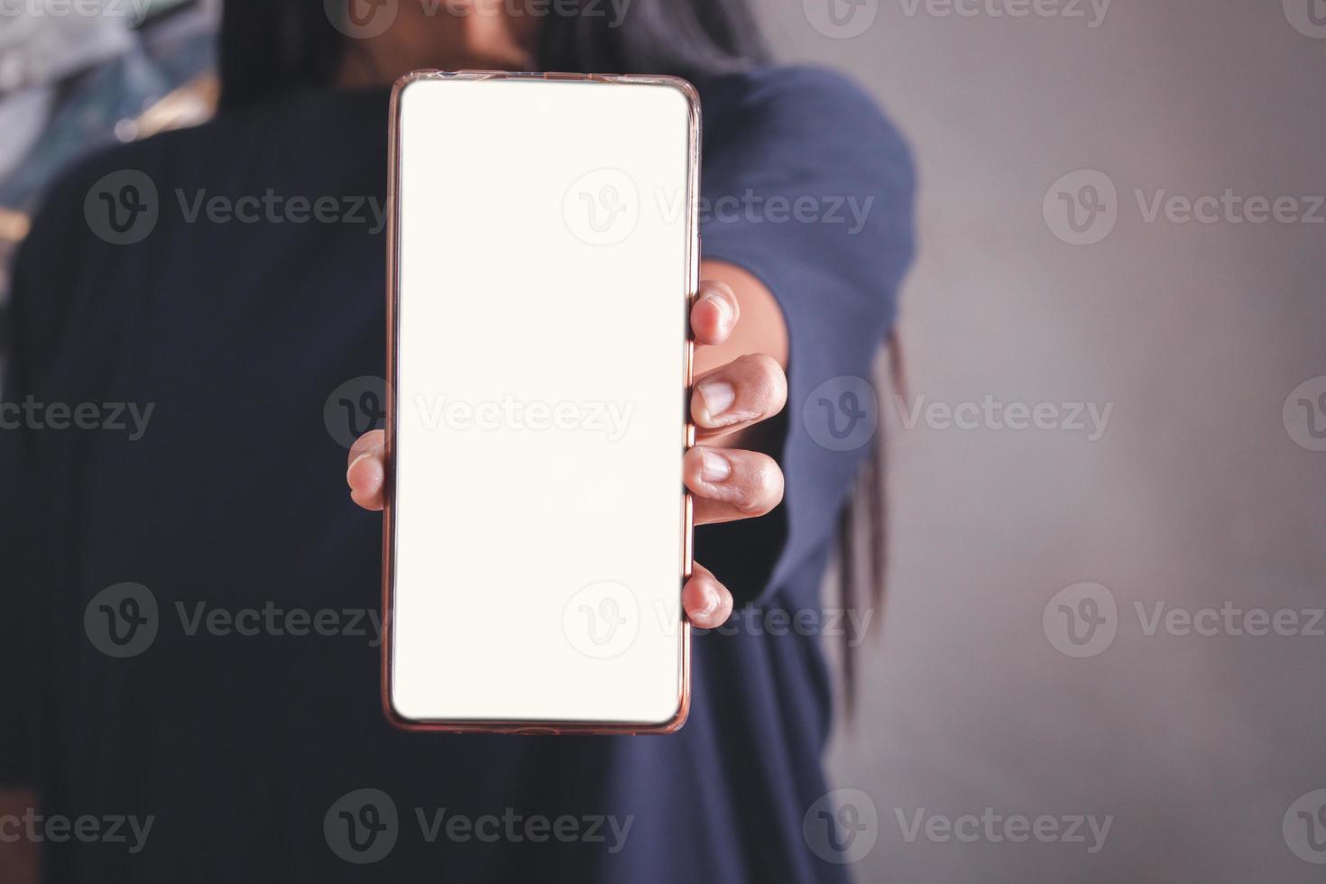 Mockup image of a holding black mobile phone with blank white screen photo