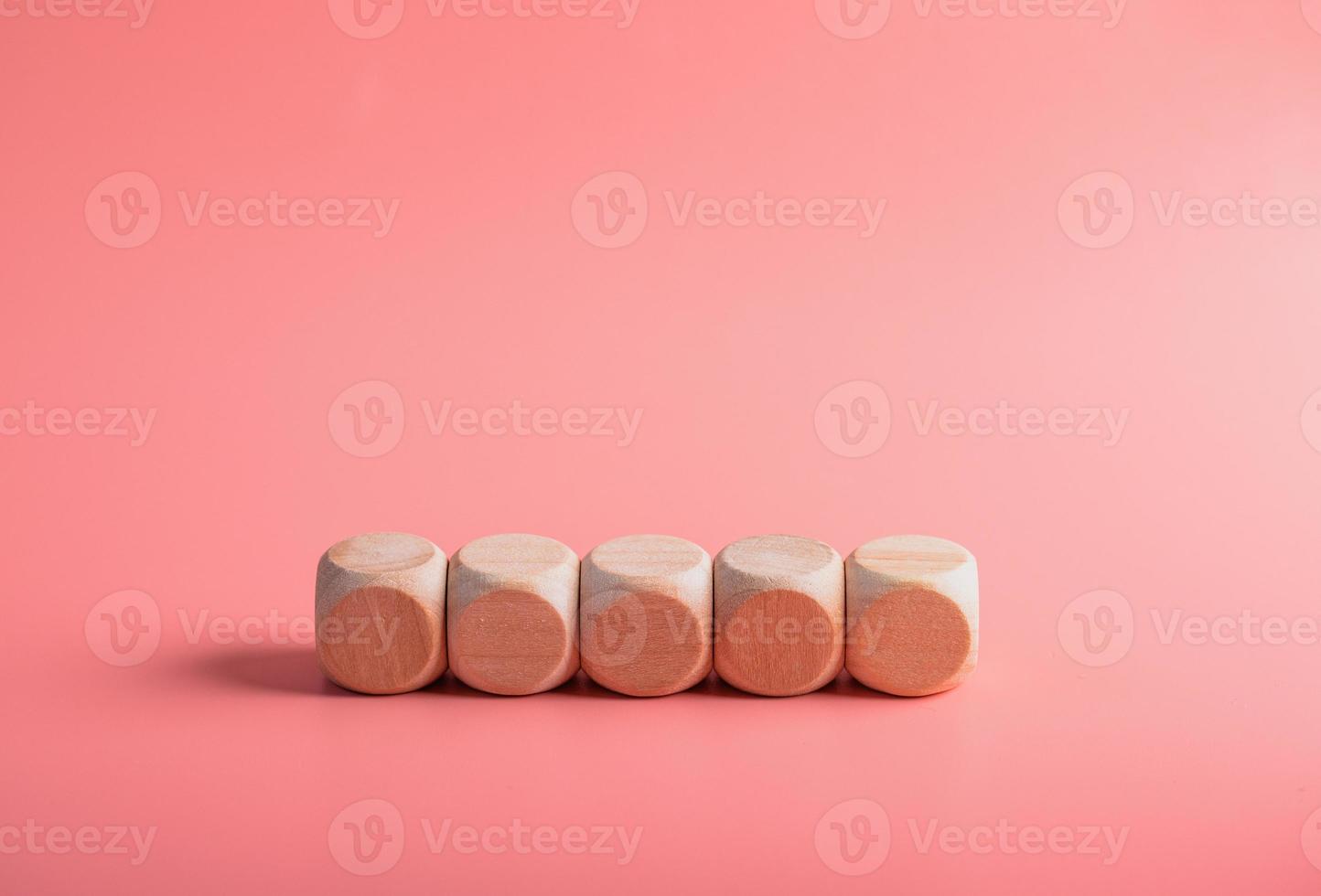 blank wooden dice for inserting text.on pink background photo
