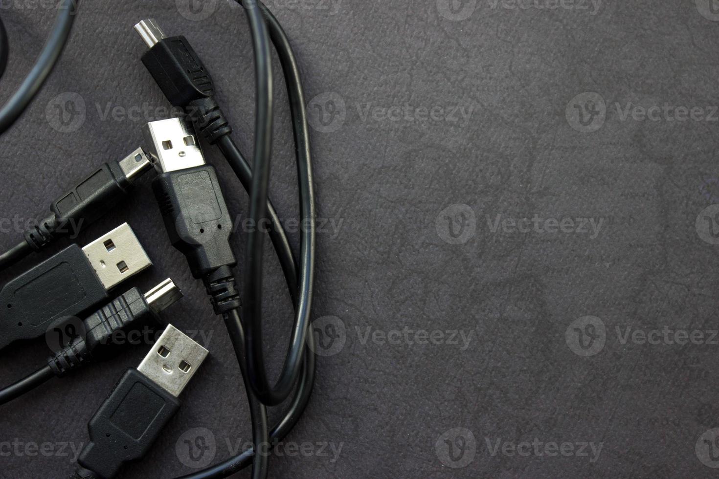 Close up USB and mini USB cables on black background with place for your design photo