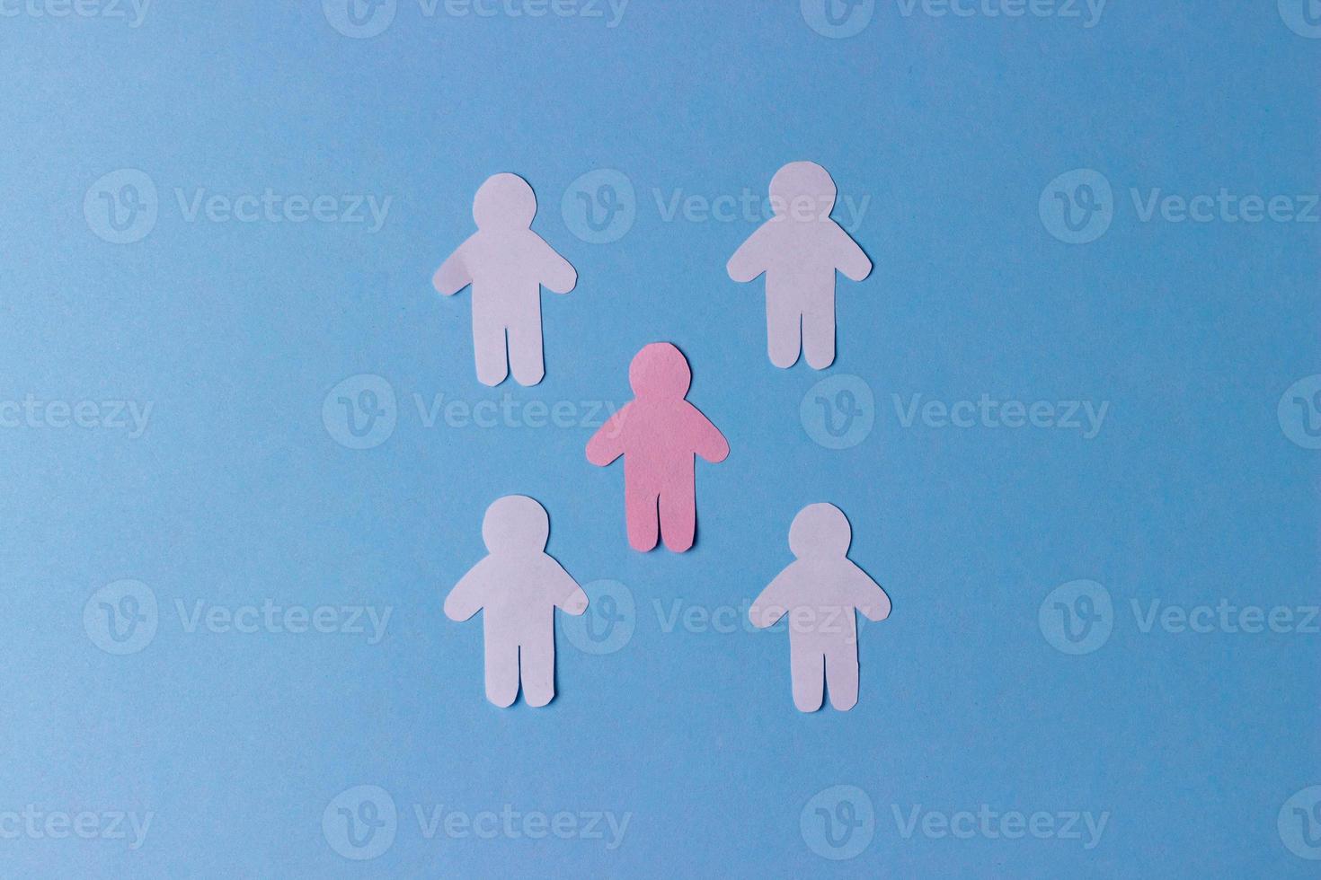 People cut out of paper. Pink silhouette of a man surrounded by white silhouettes. The concept of communication, teamwork, society photo