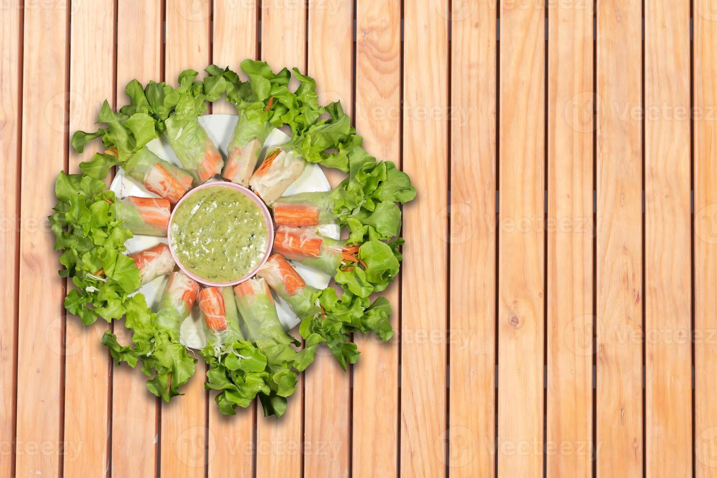 Top view salad rolls in dish on the wooden background photo