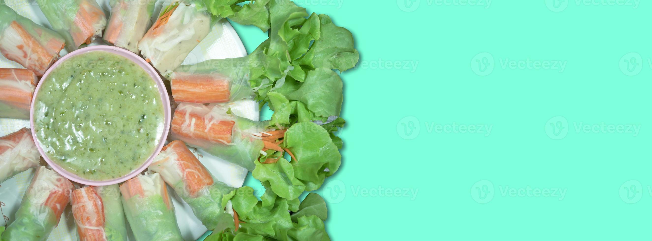 top view salad rolls in dish on the green background photo