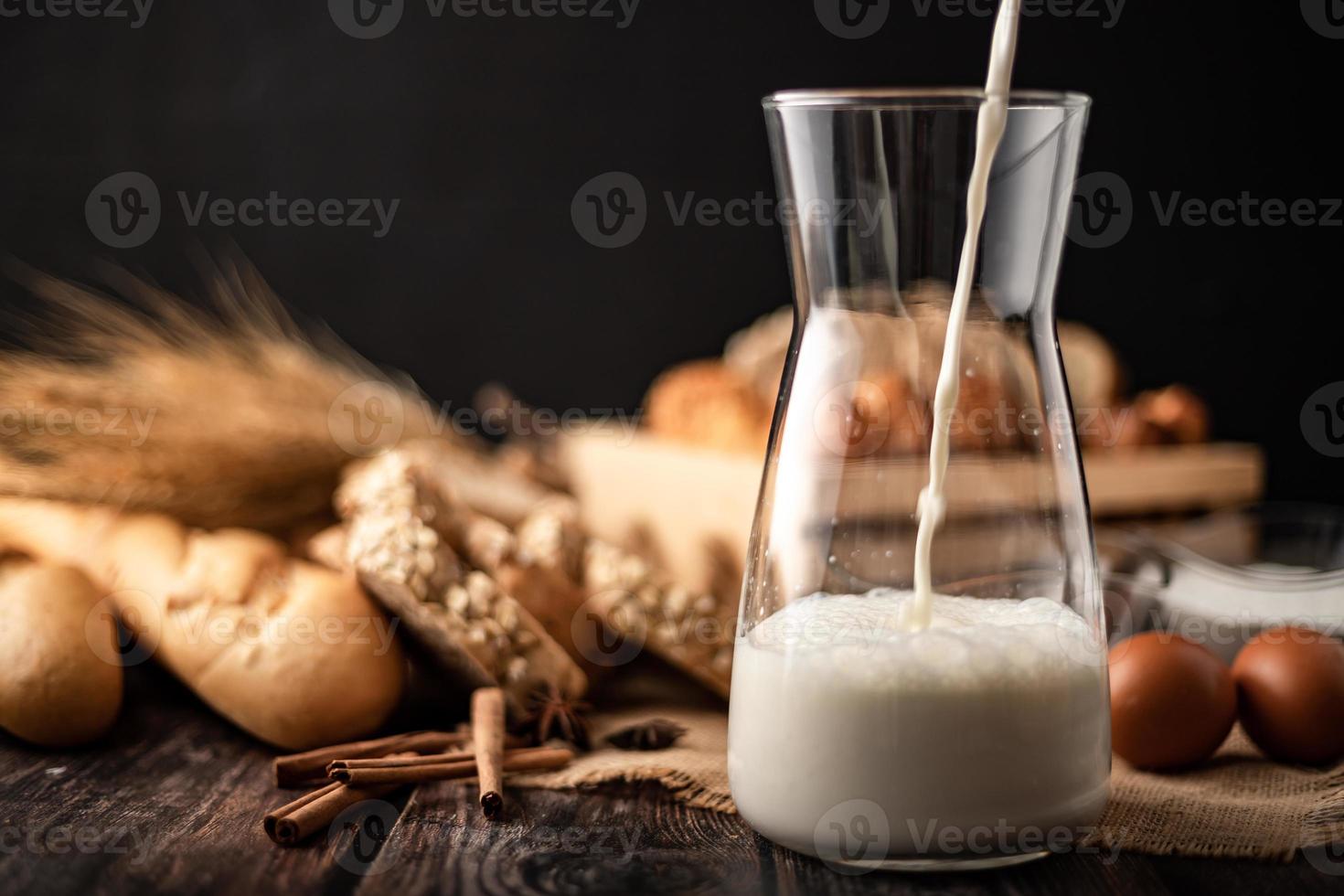 Pour the milk in a glass bottle placed on the sack photo