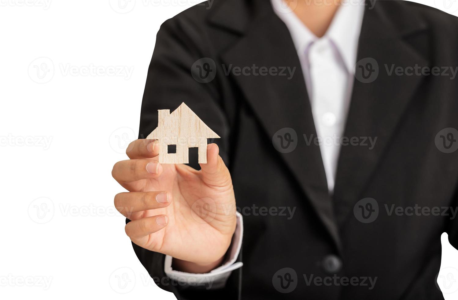 The woman wearing a black suit used a hand right holding a simulated wooden house photo